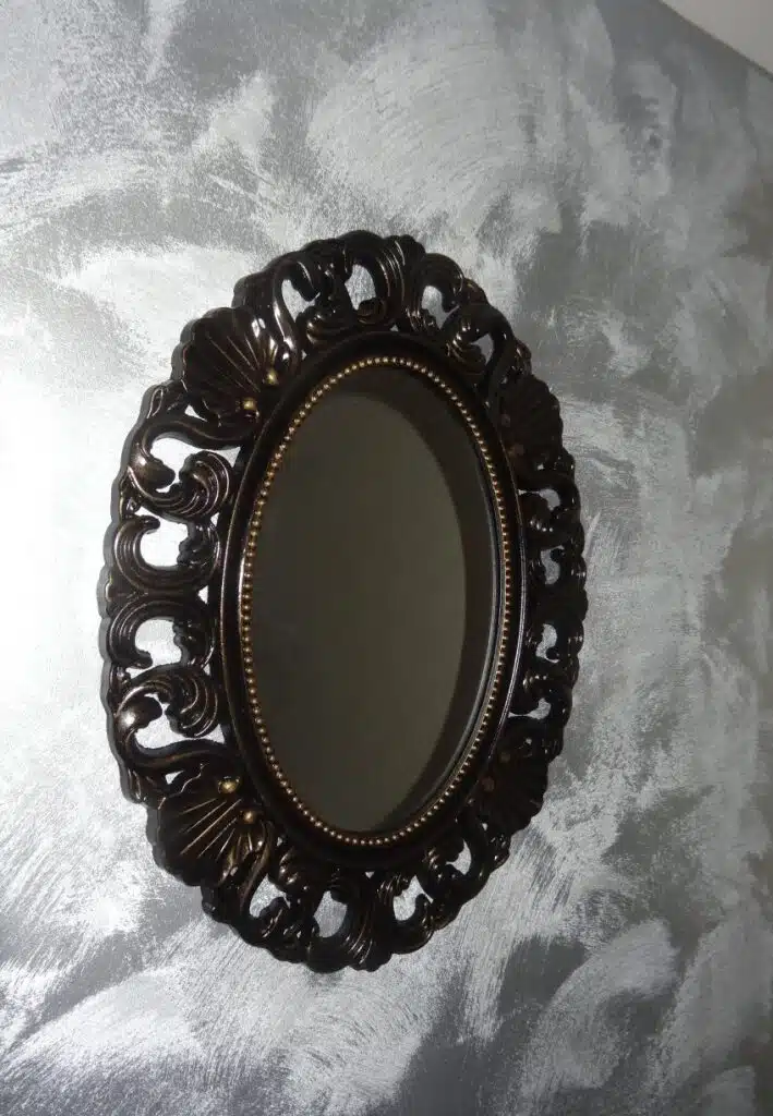 Miroir ovale noir patiné or